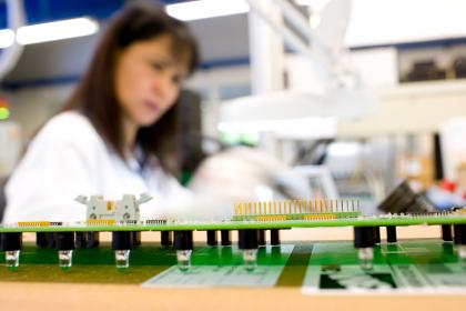 Produktbild - Platine 01 Mitarbeiterin bei der Handbestückung von Platinen